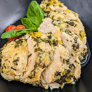 Close look of juicy chicken breast with basil leaf and cherry tomatoes.