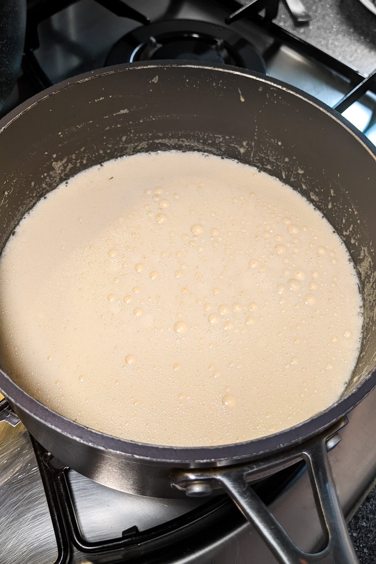 Boiled creamy sauce in a sauce pan on the stove.