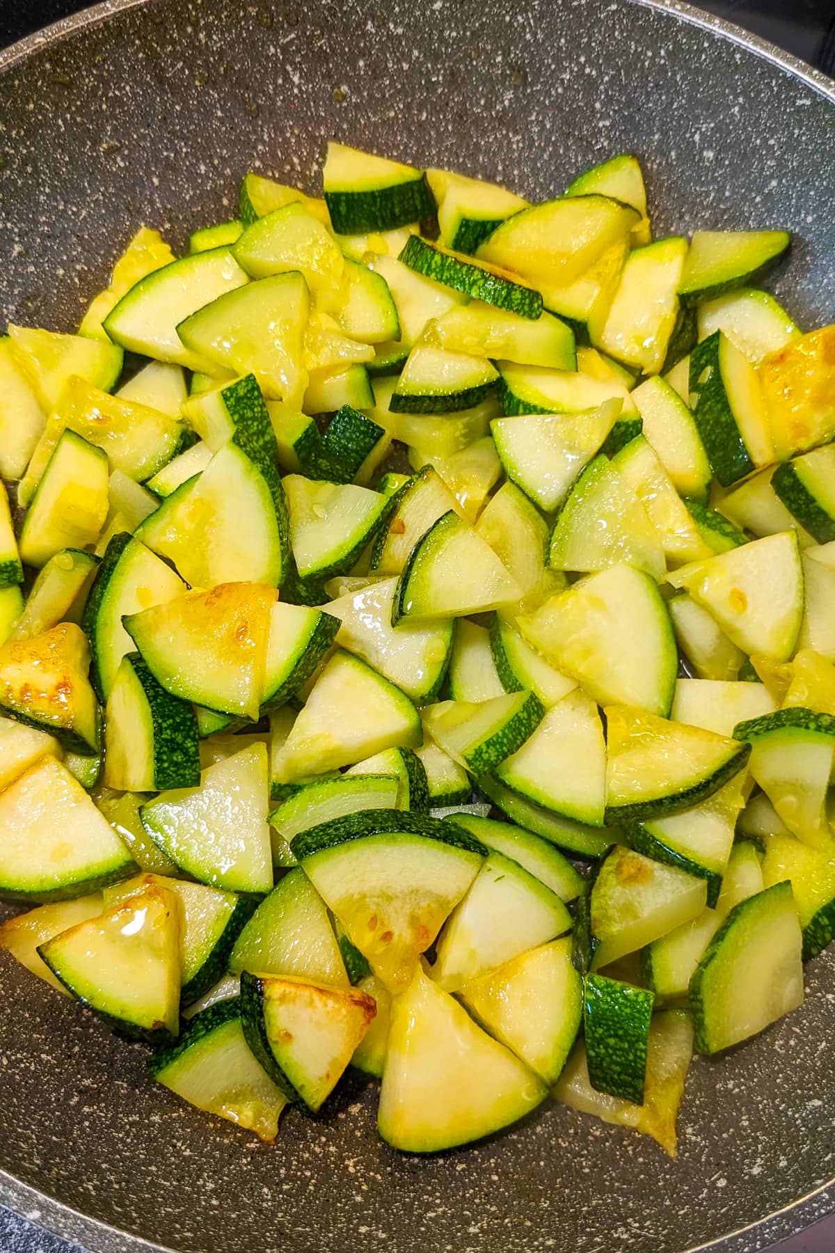 Frying pan with fried zucchini slices.