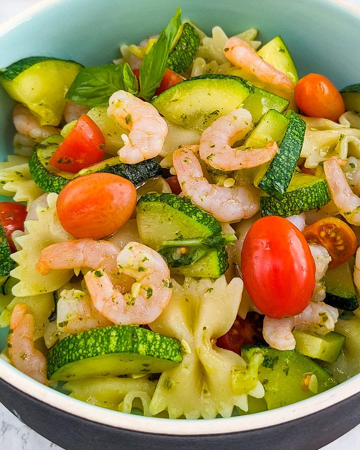 Close look of shrimp pasta salad with cherry tomatoes, and salad dressing.