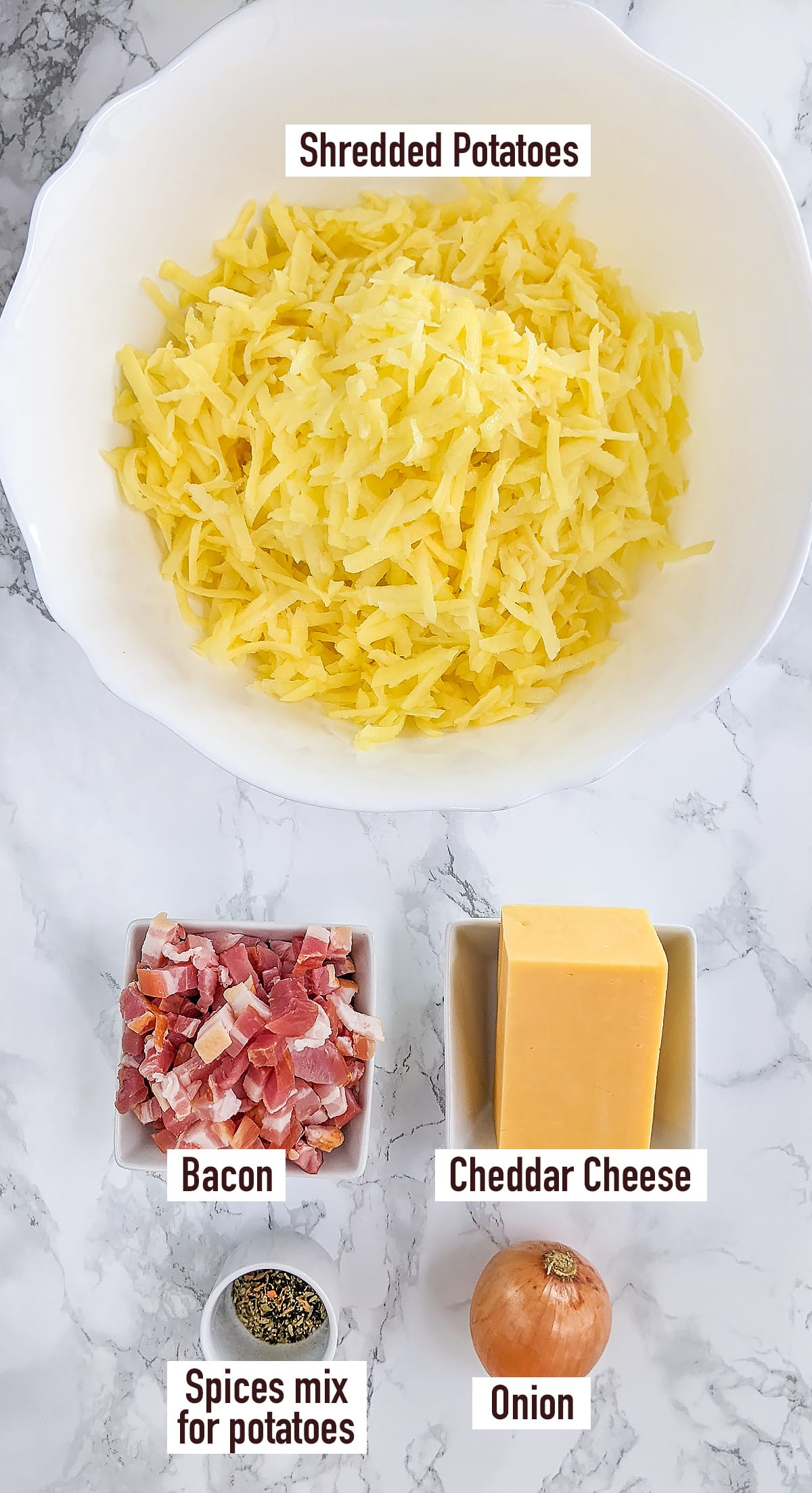 White plate with shredded potatoes, bacon, cheddar and onion.