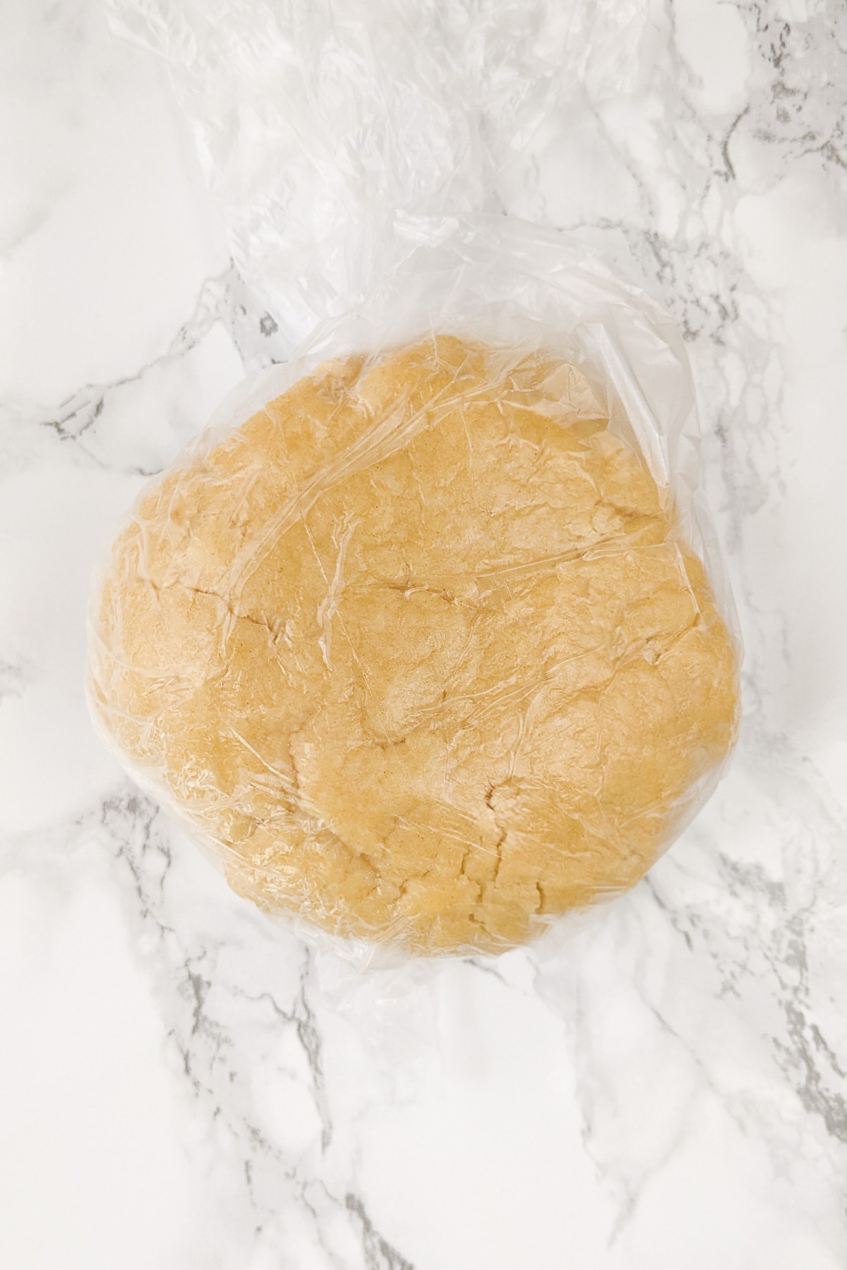 Biscuits dough in a plastic package on a marble table.