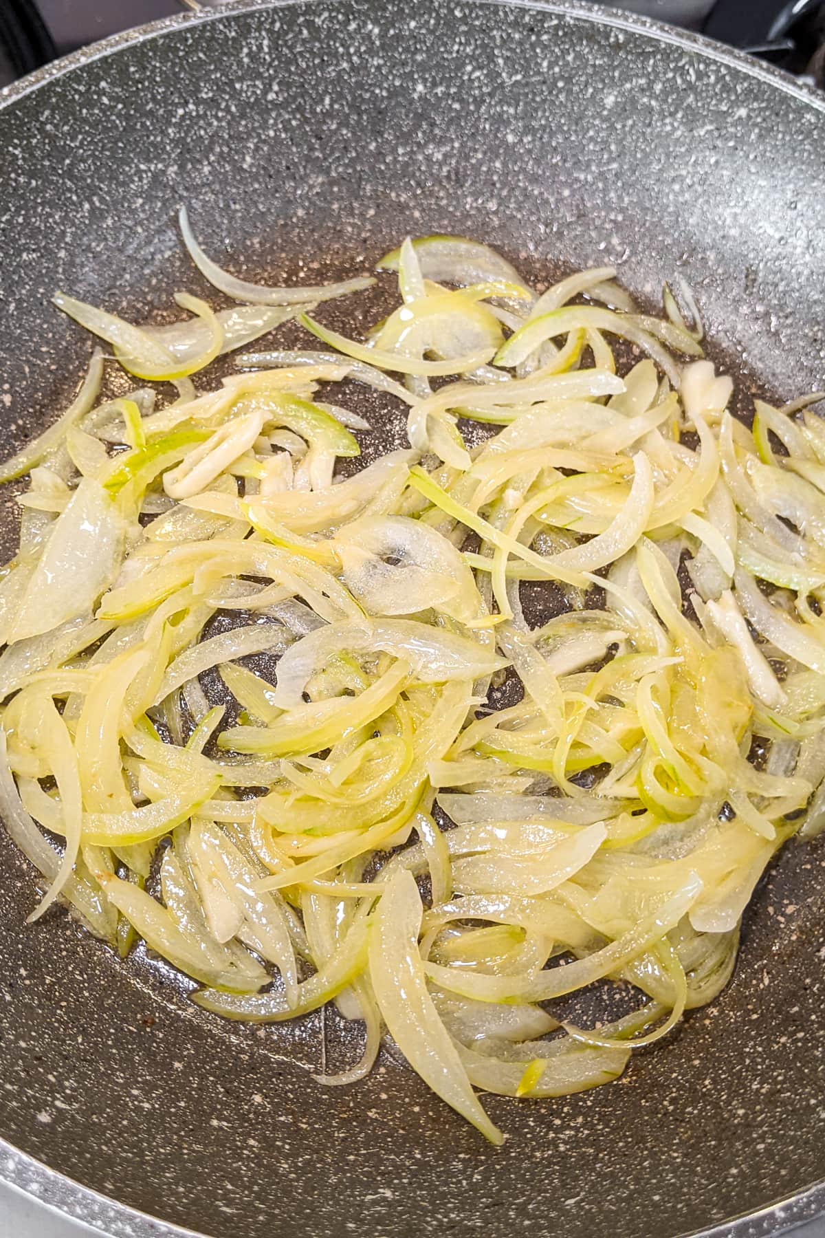 Fried onions in a frying pan on the stove.