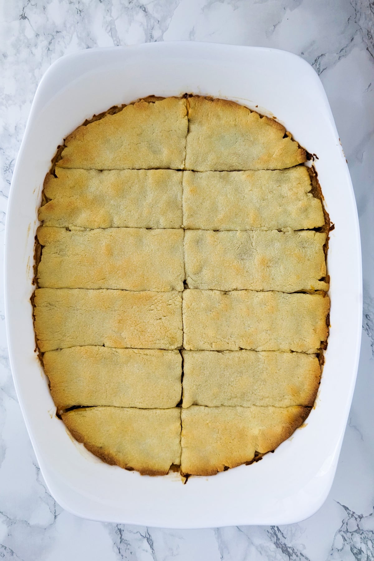 Top view of sliced apple cake in a casserole.