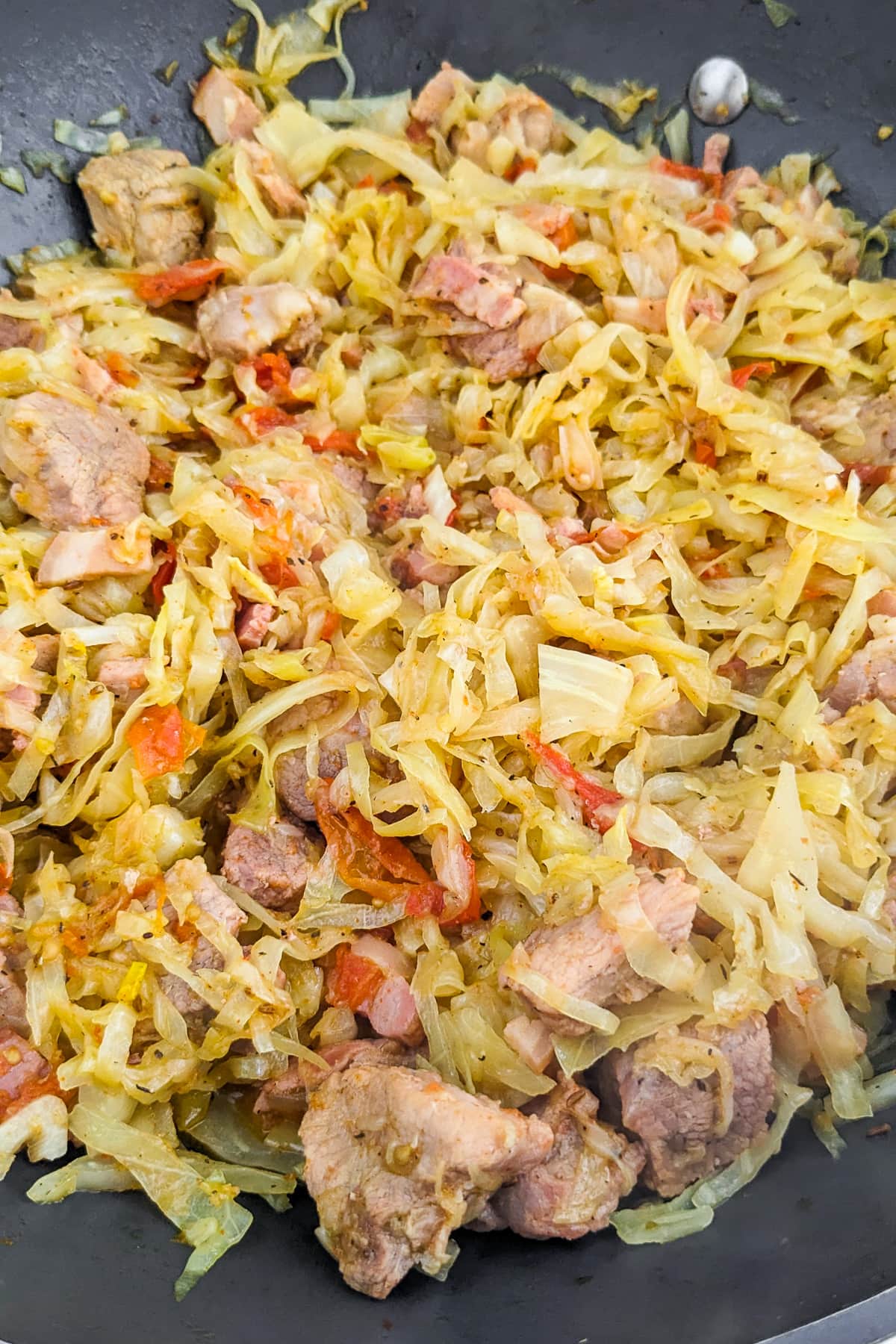 Mixed shredded cabbage with meat, onions and tomatoes.