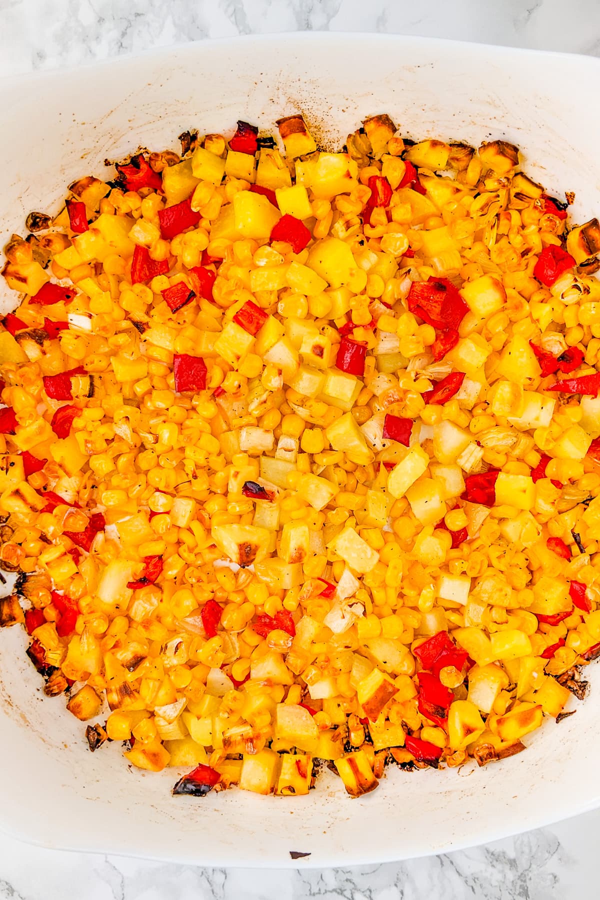 Oven-baked corn hash on a white marble table.