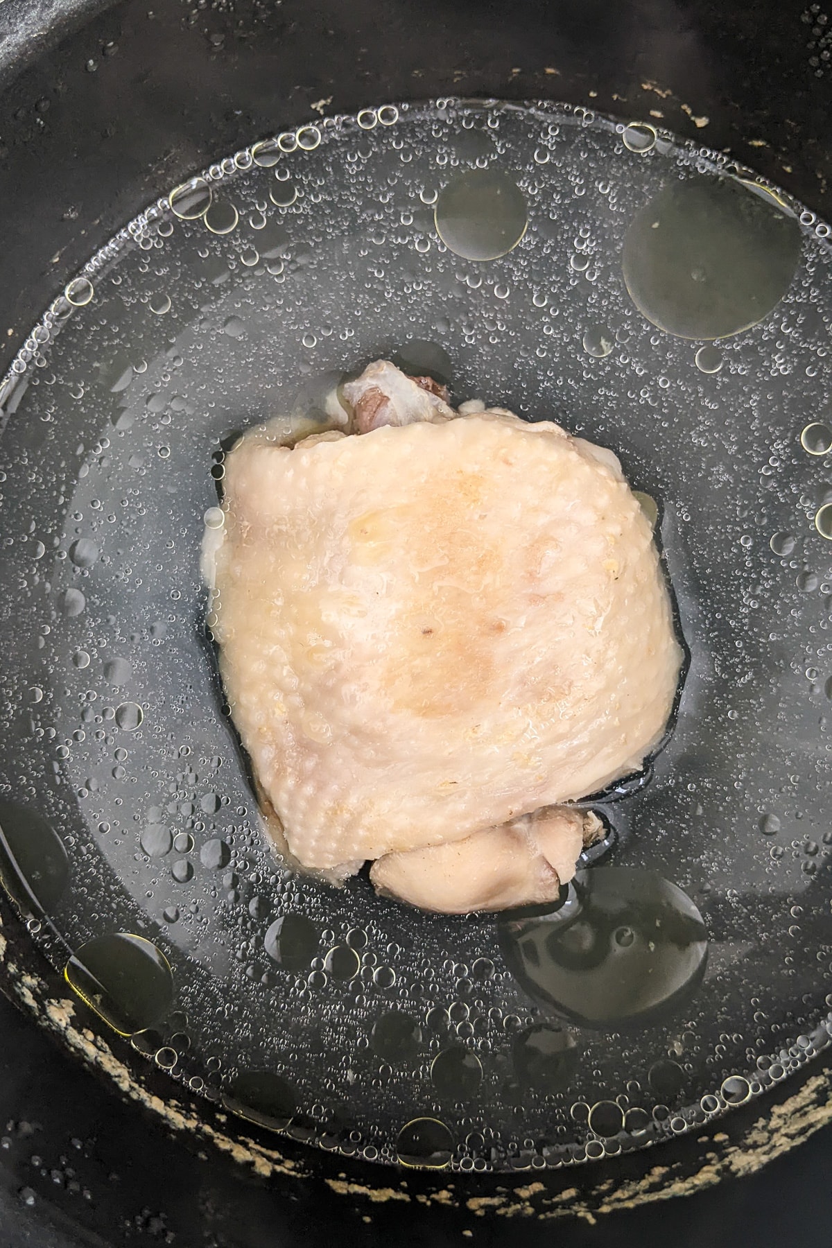 Top view of boiling chicken with in a saucepan.