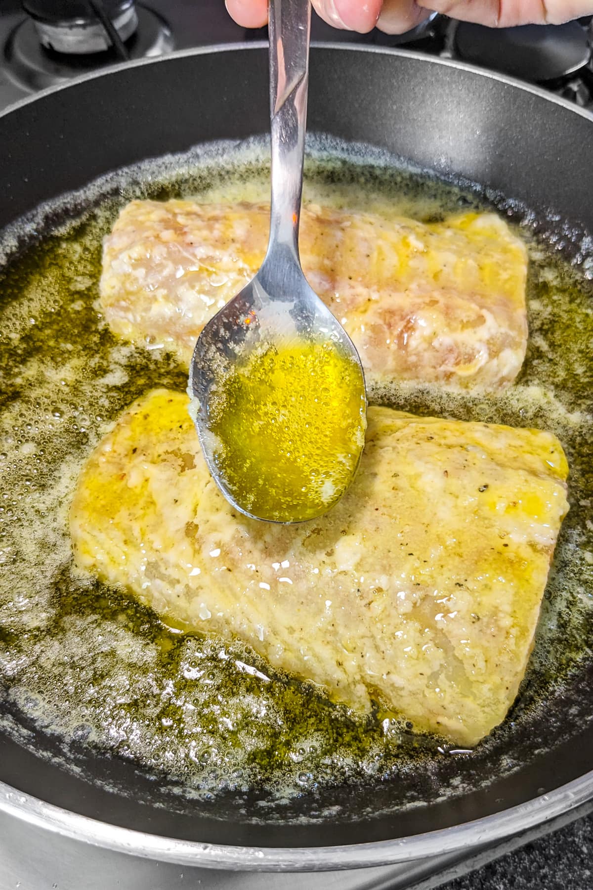 Covering fish fillets with meuniere sauce.