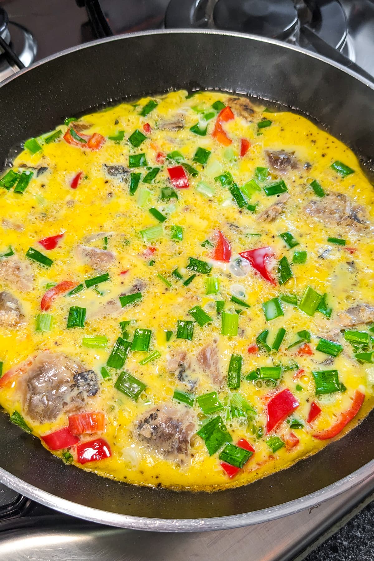 Top view of sardine omelette in a frying pan.