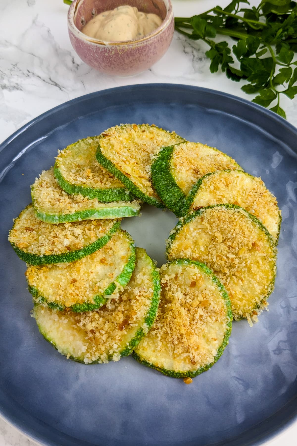 Elegantly served zucchini casserole slices on a blue plate.