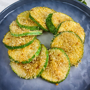 Close look of elegantly served zucchini casserole slices on a blue plate.