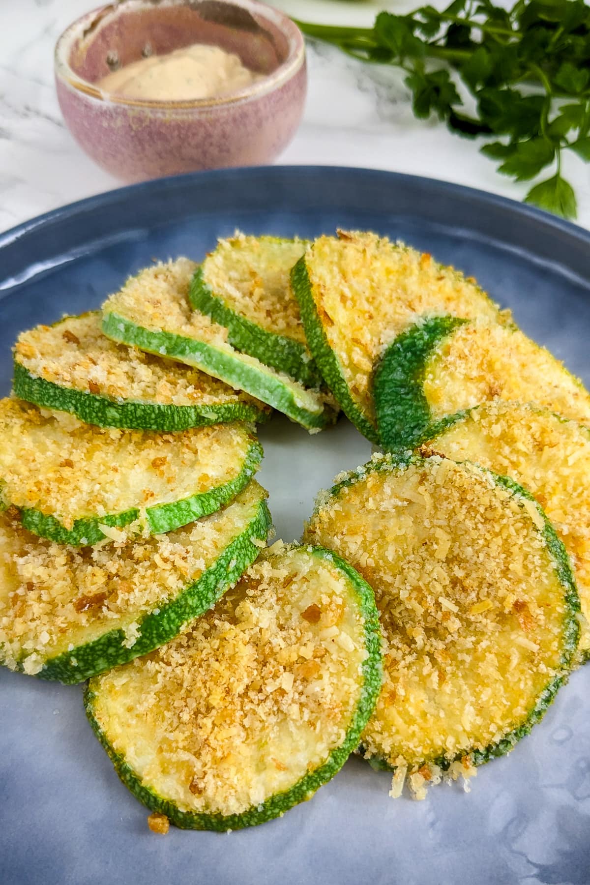 Elegantly served zucchini casserole slices on a blue plate.