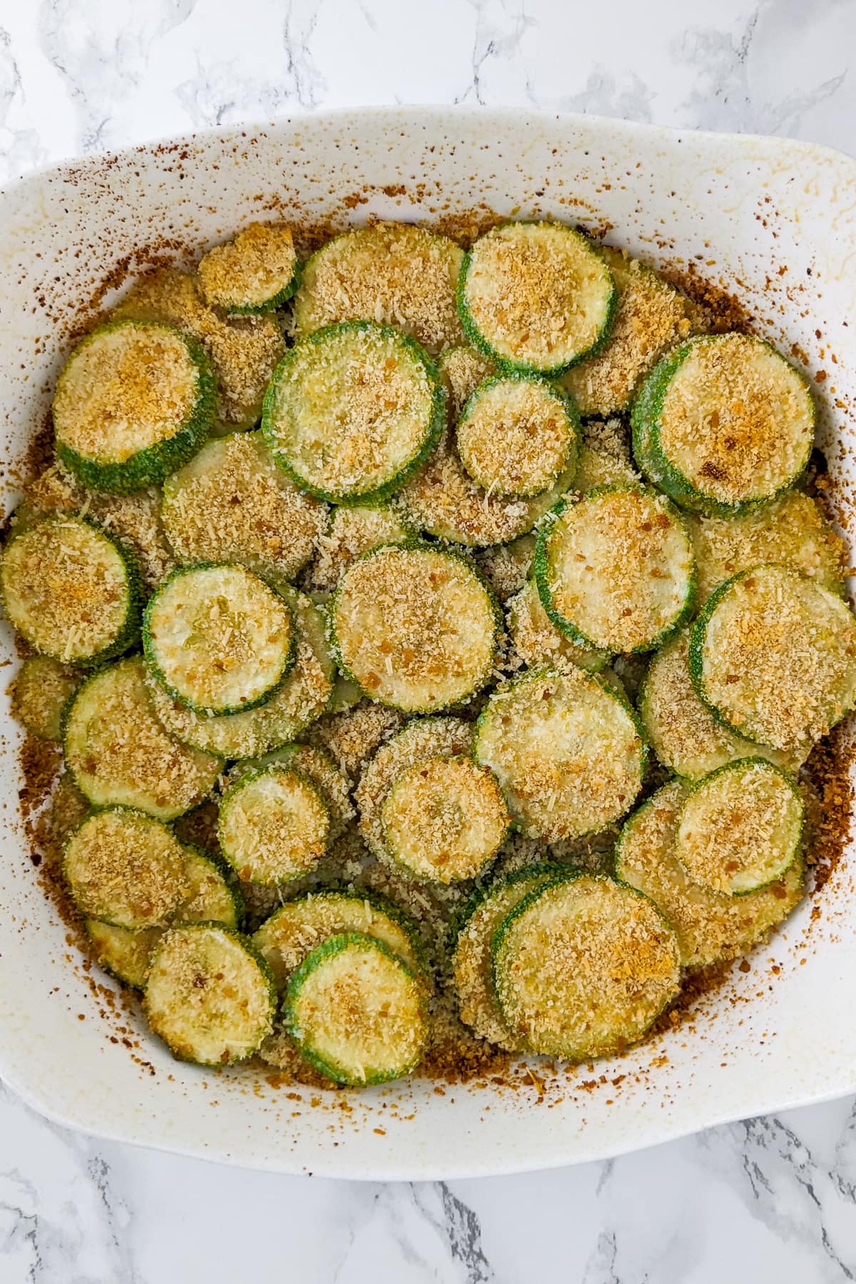 Top view of fried zucchini slices in a casserole.
