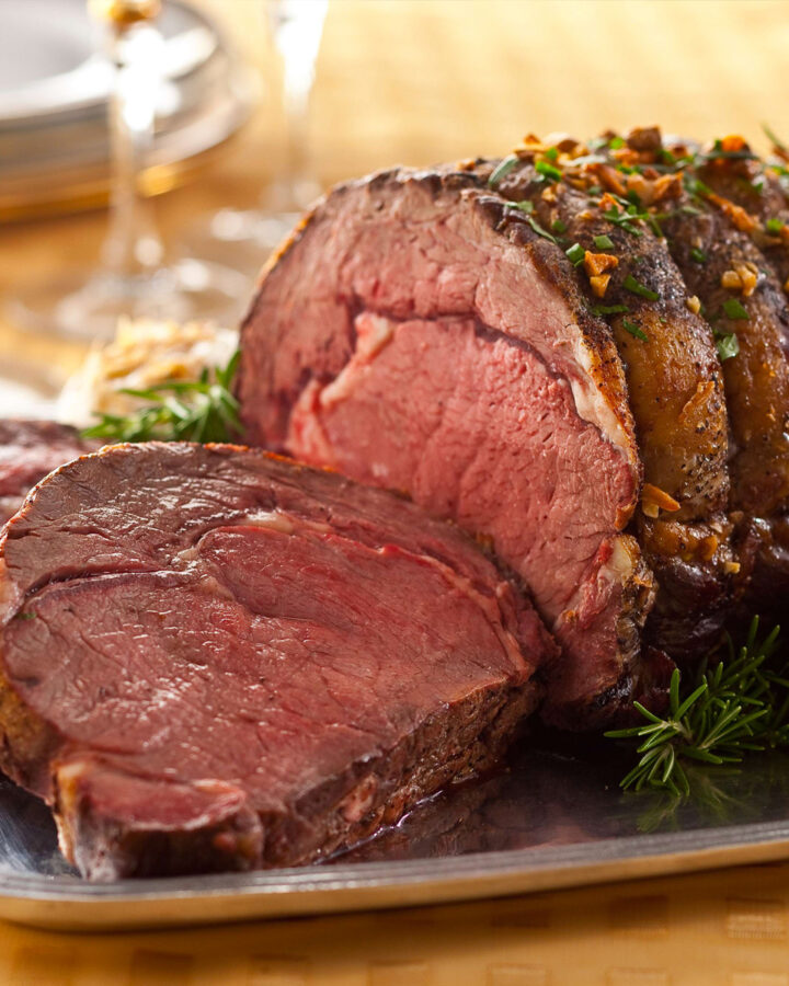Close look of juicy beef join roast served on a metal plate.