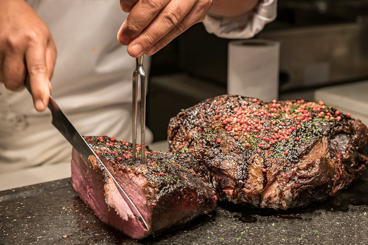 A chef slicing beef joint that was cooked from frozen.