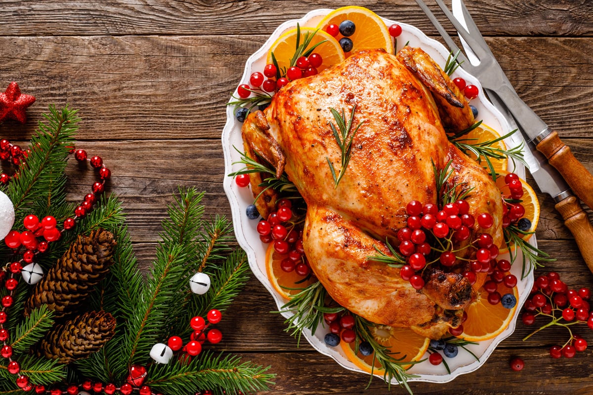 Close look of roasted Christmas turkey with grapes, and oranges.