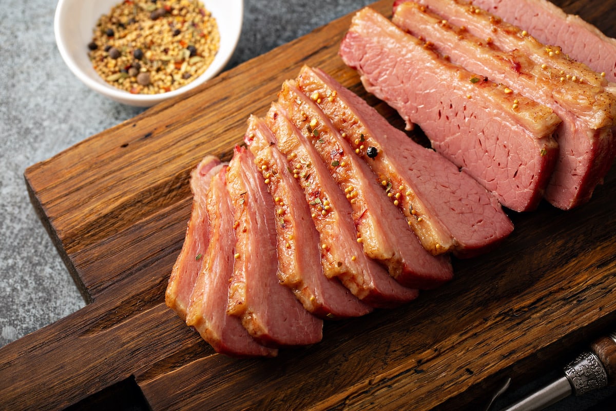 Close view of sliced corned beef with mustard.