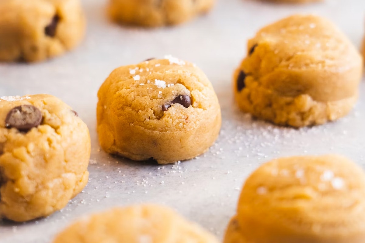 Close look of raw chocolate chip biscuits on baking paper.