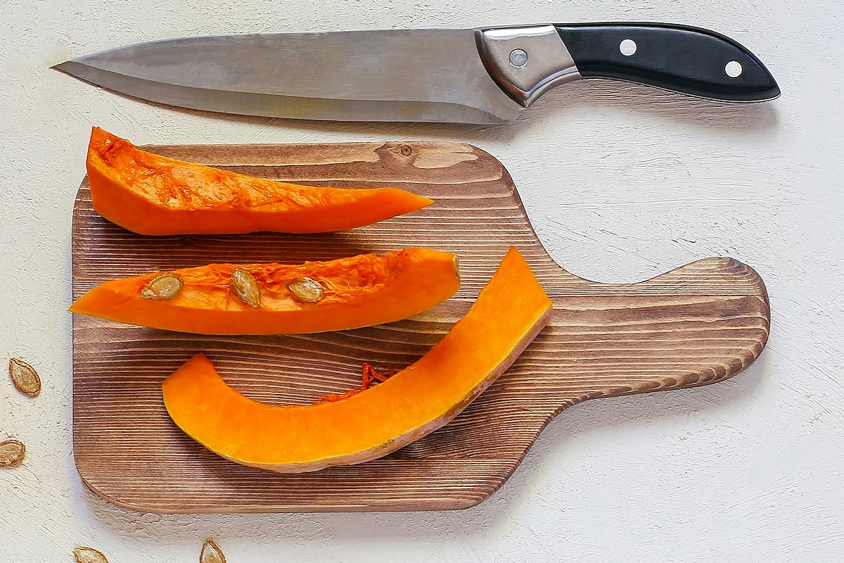3 slices of squash on a wooden cutting board.