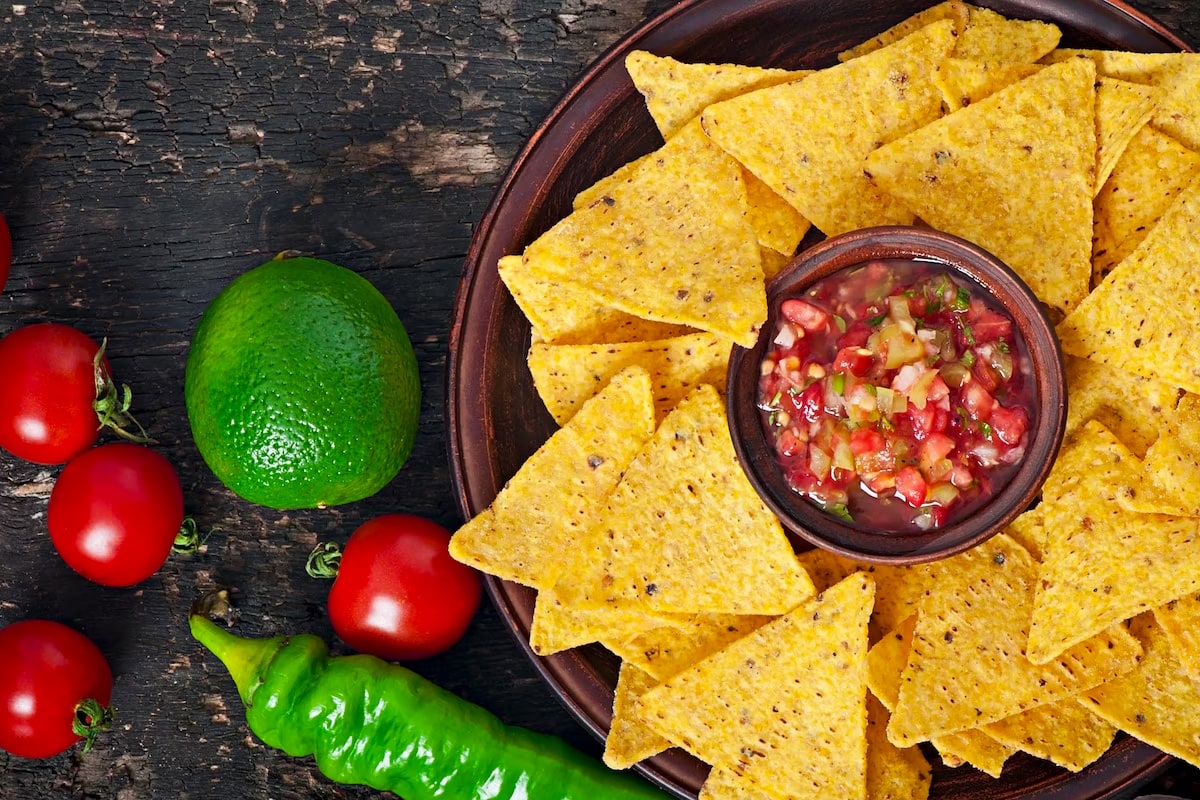 Top view of tortilla chips substitutes served near a salsa.