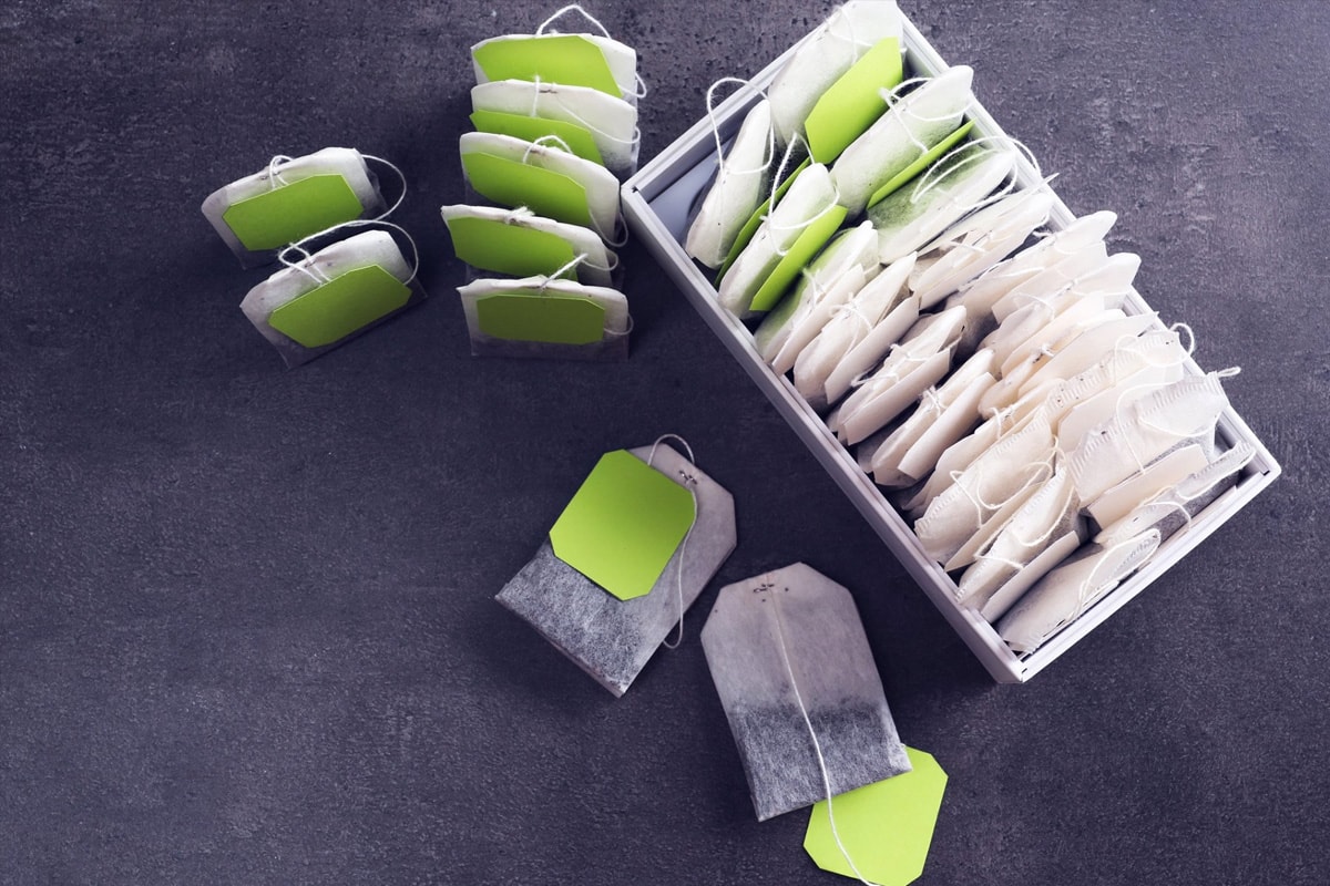 Top view of different tea bags isolated on a dark gray background.