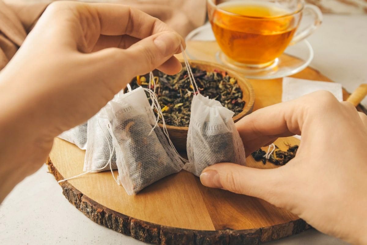 Two woman's hands holding a tea bag.