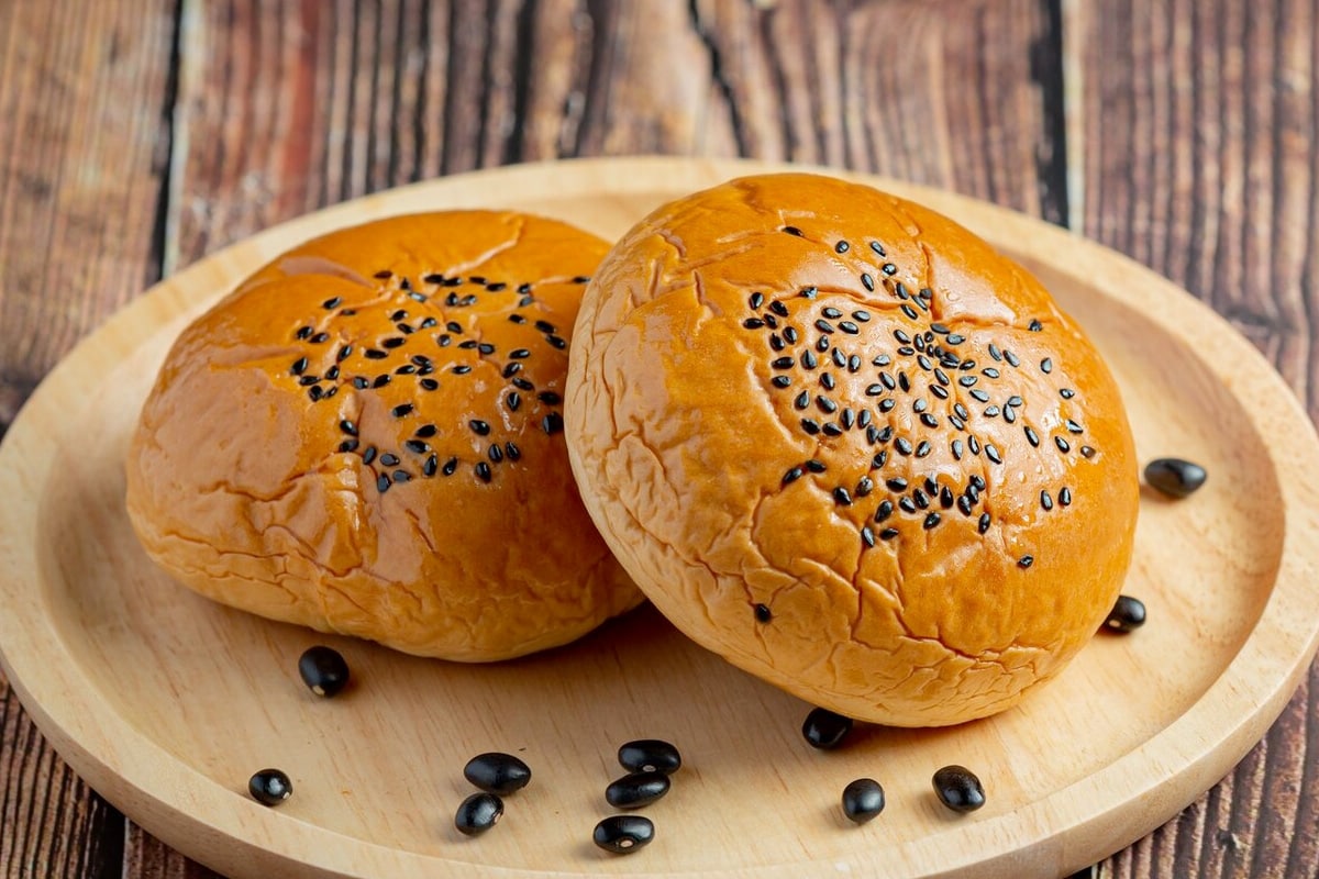 Close look of two brioche buns with black seeds on them.
