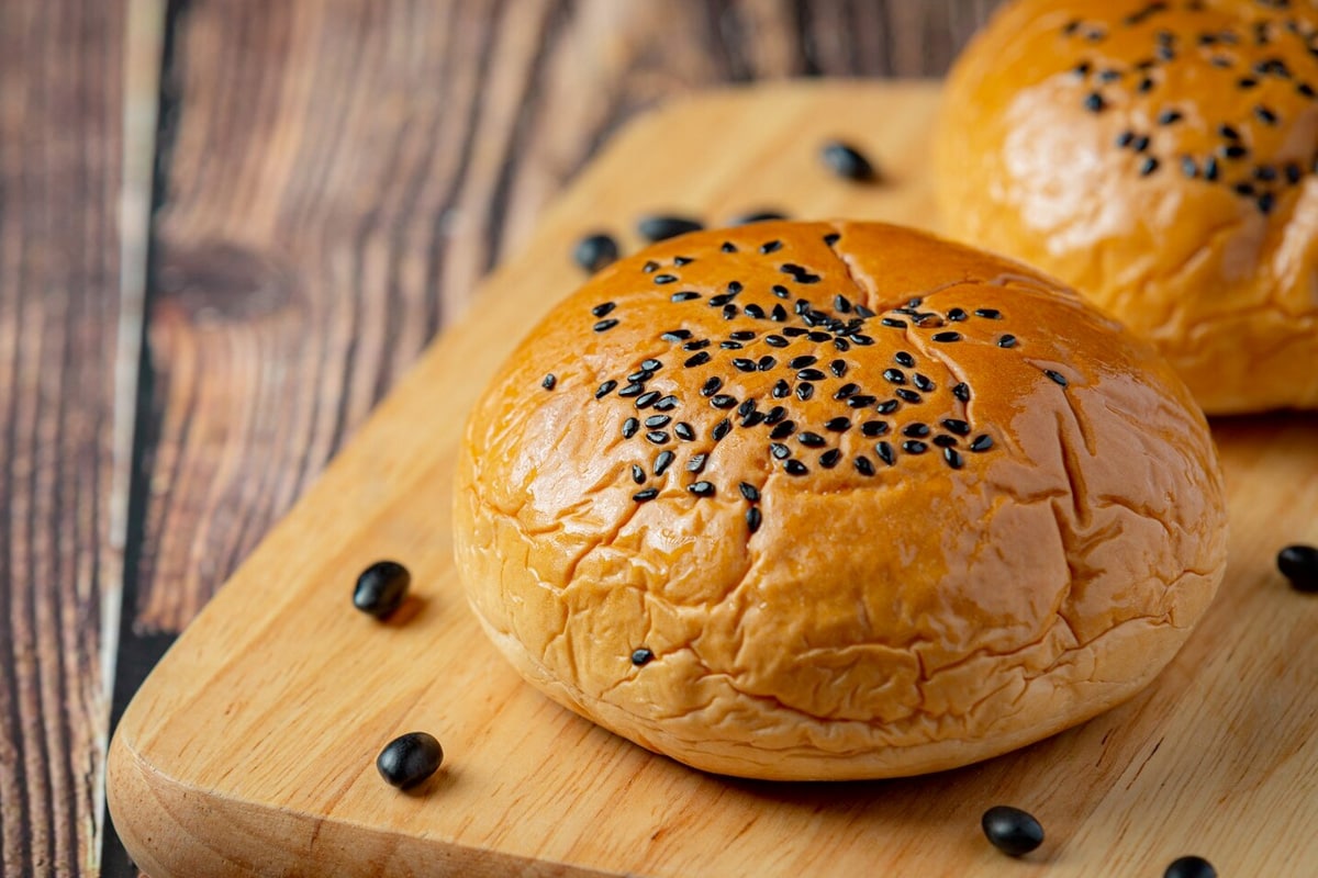 Close view of a brioche bun with black seeds on it.
