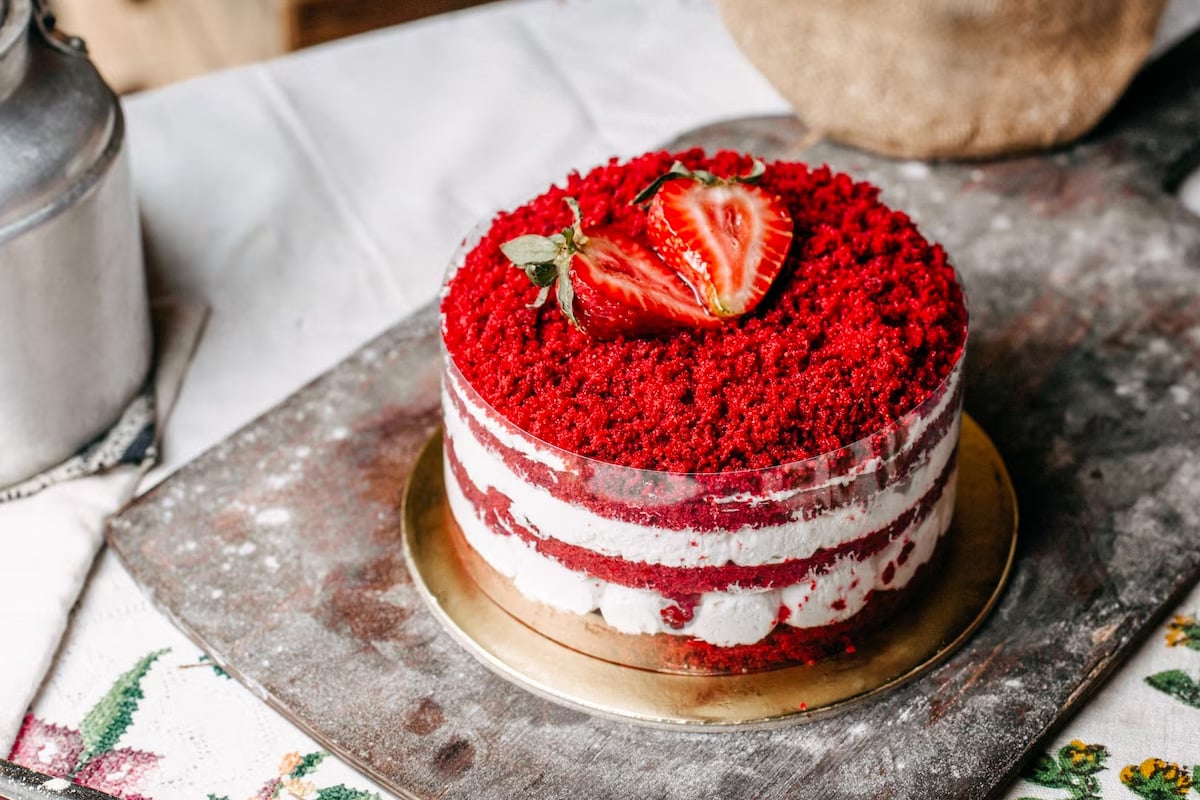 Close look of a red velvet cake with two strawberry halves on it.