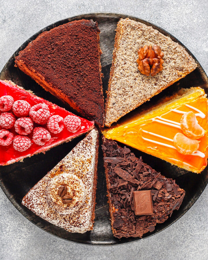 Top look of a black plate with different types of cakes.