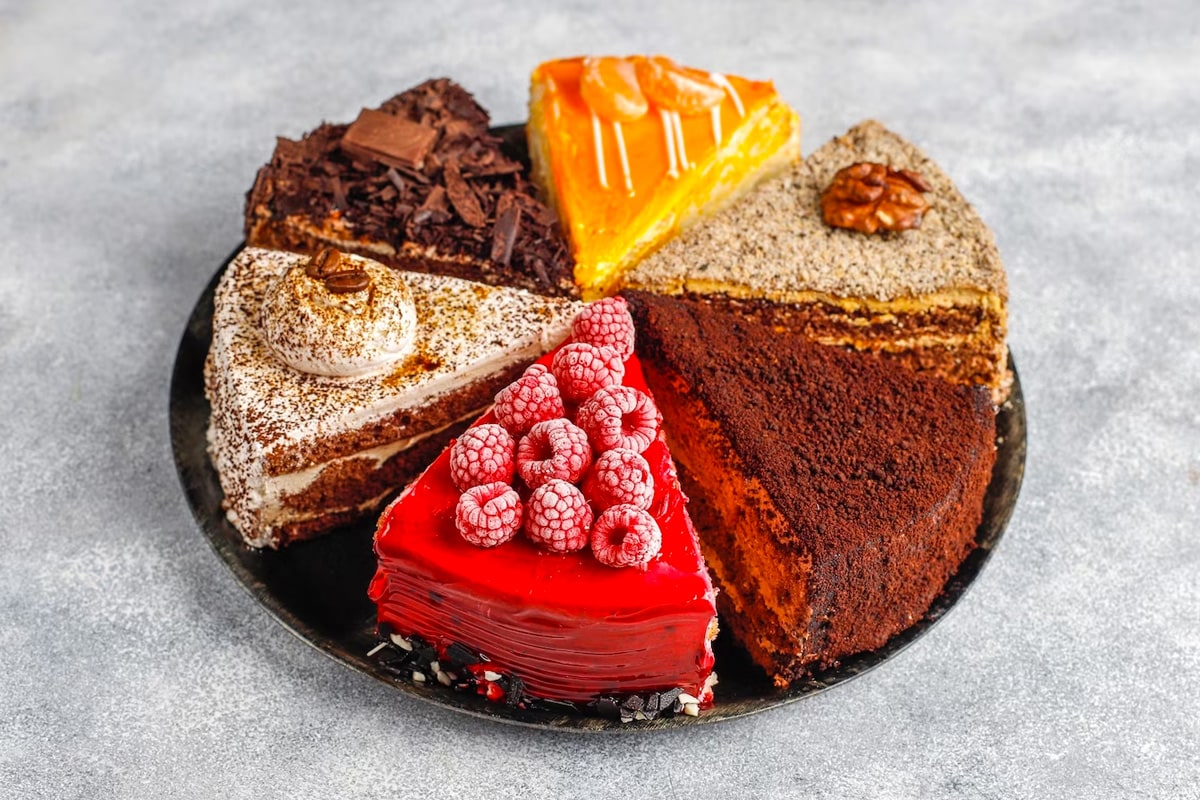 Close look of a round plate with 6 types of different cake slices.