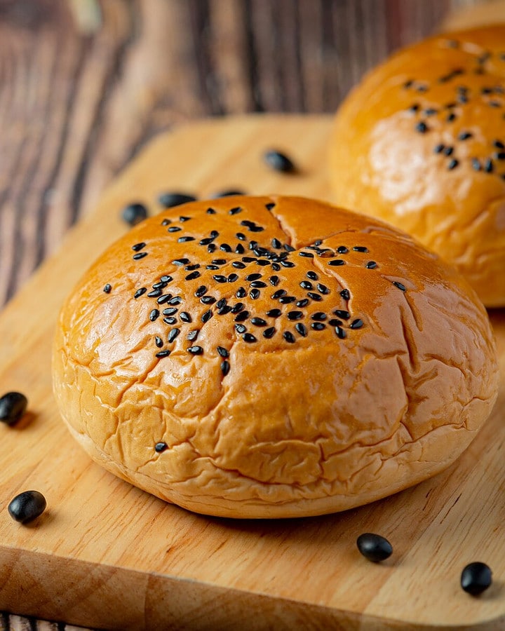Close look of a brioche bun with black seeds on it.