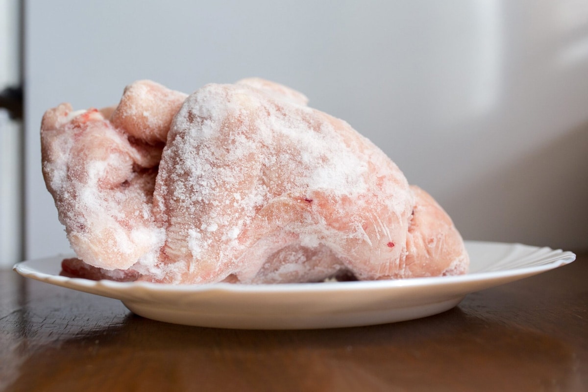 Close look of frozen chicken on a white plate.