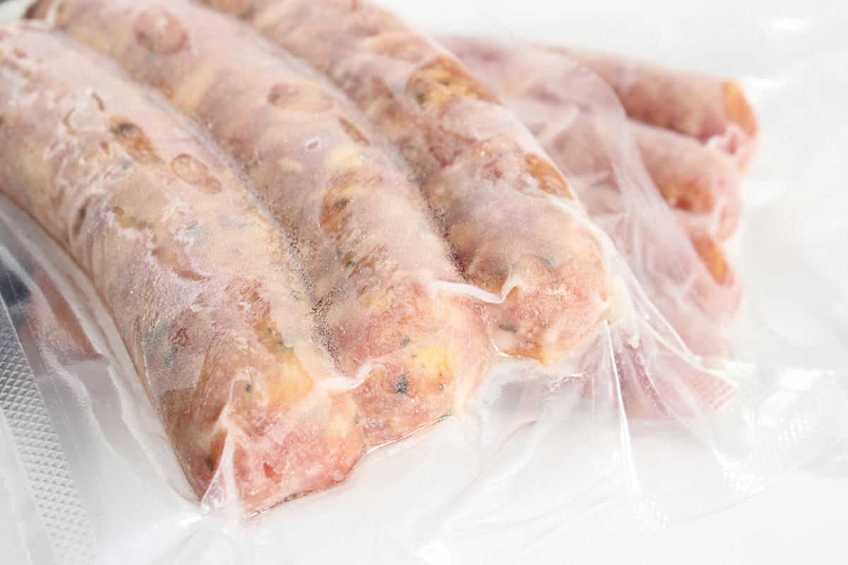 Close look of frozen sausages in a freezing bag.