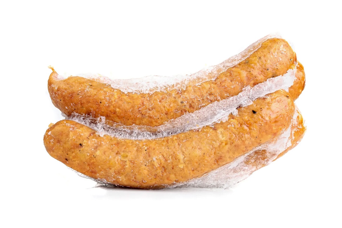 Side look of 4 frozen sausages isolated on a white background.