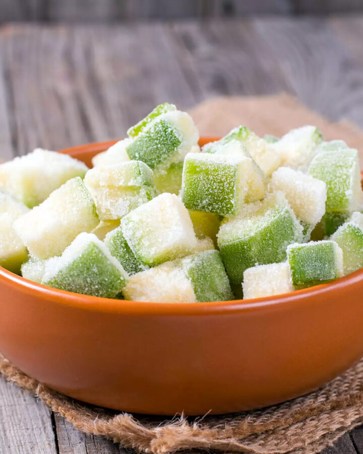 A ceramic brown bowl with frozen zucchini cubes.