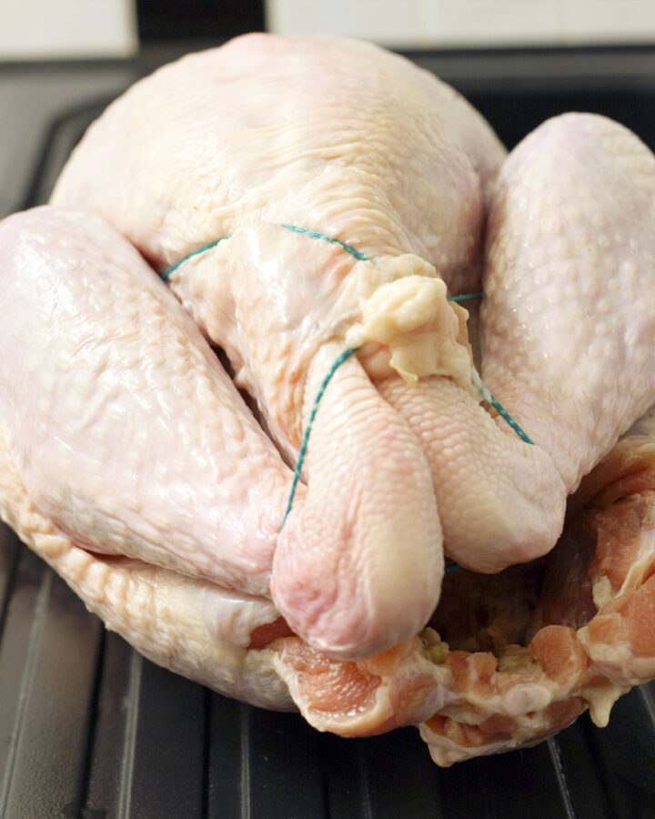 A close look at thawed turkey tied with a rope.