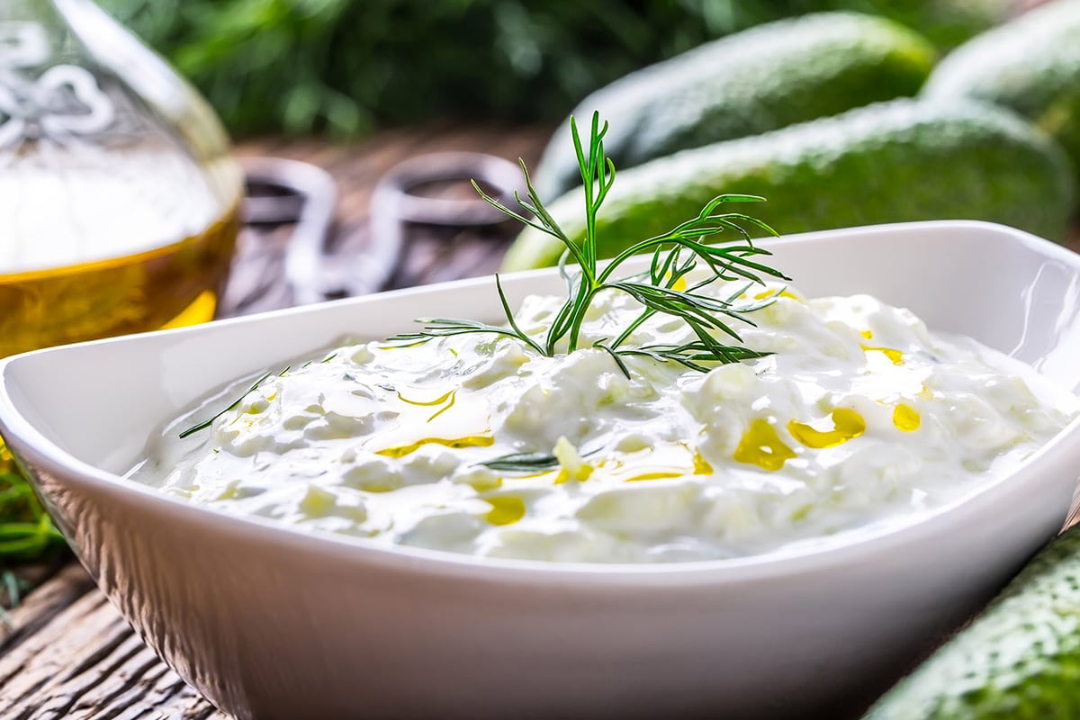 Close look of tzatziki sauce with olive oil and fresh dill in it.