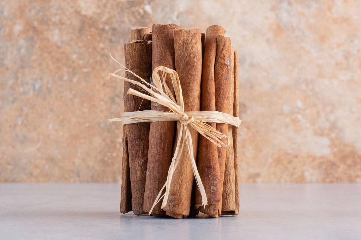A few pieces of cinnamon sticks with a rope sitting on the table.