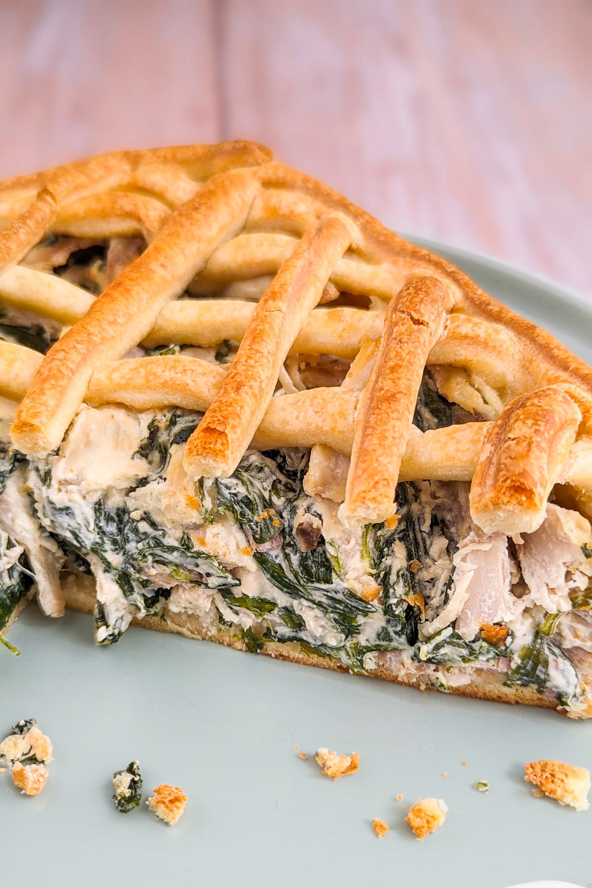 Close look of a slice of chicken pie with spinach and chicken.