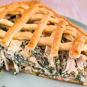 Close look of a slice of chicken pie with spinach and chicken.