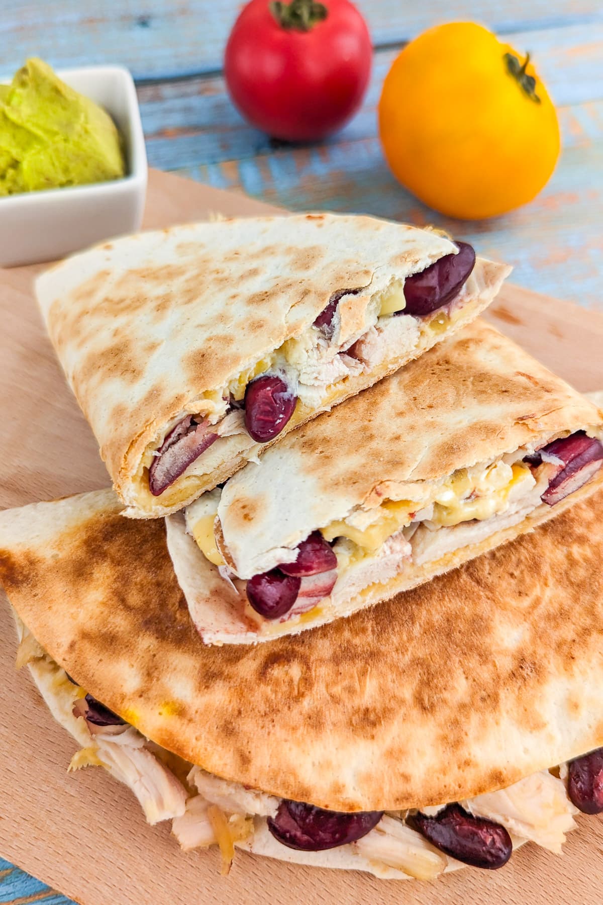 Close view of quesadilla with melted cheese, beans and chicken.