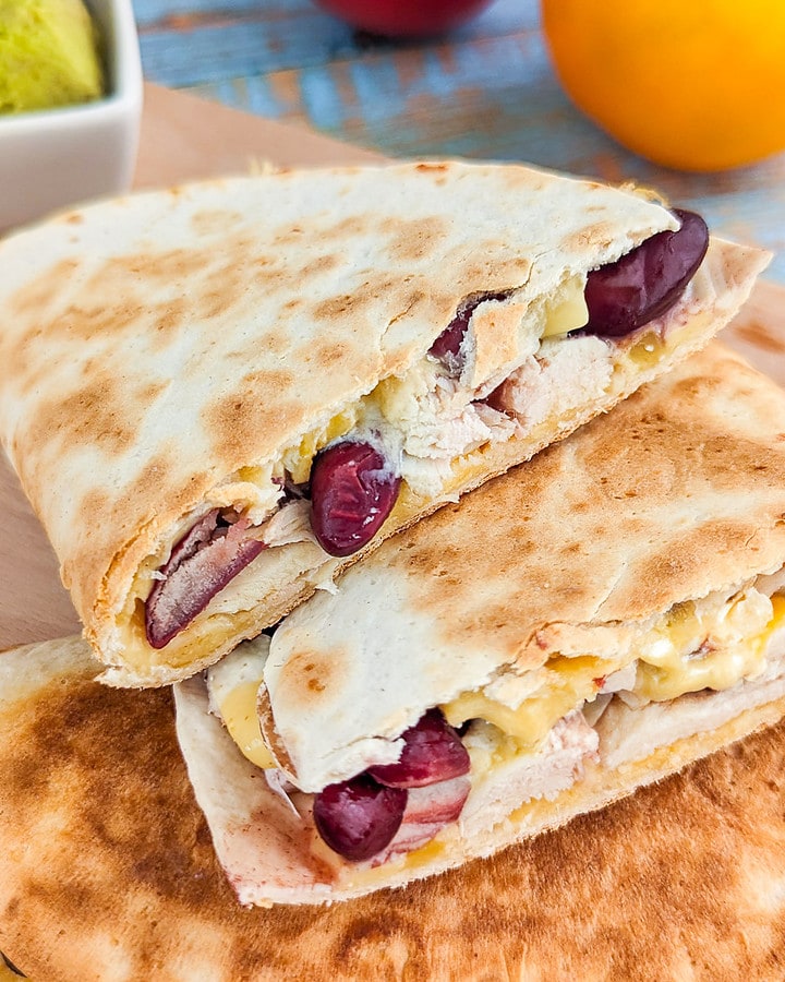 Close view of quesadilla with melted cheese, beans and chicken.