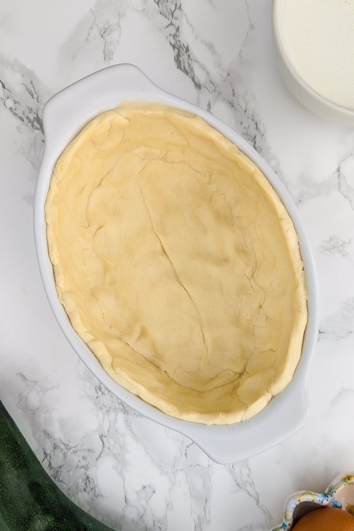 Top view of a baking pan covered with a thin layer of dough.