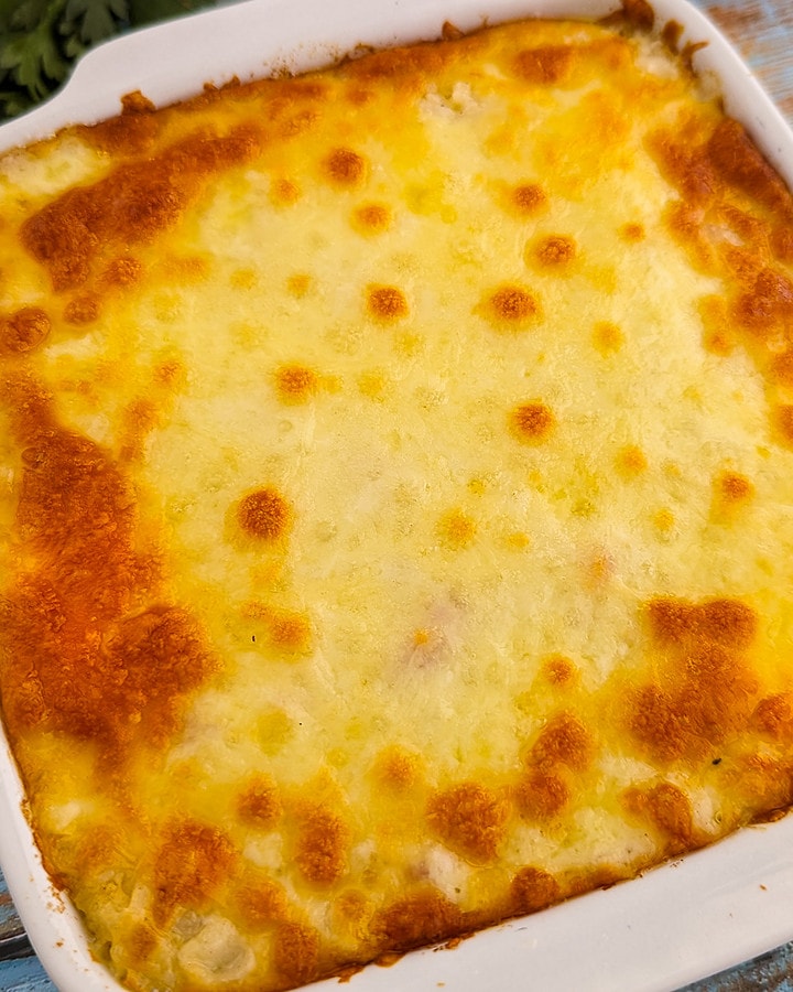 Close look of baked rice cheese on a rustik blue wooden table.
