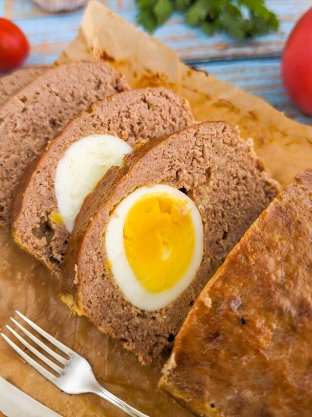 Close look of sliced meatloaf with boiled eggs inside.