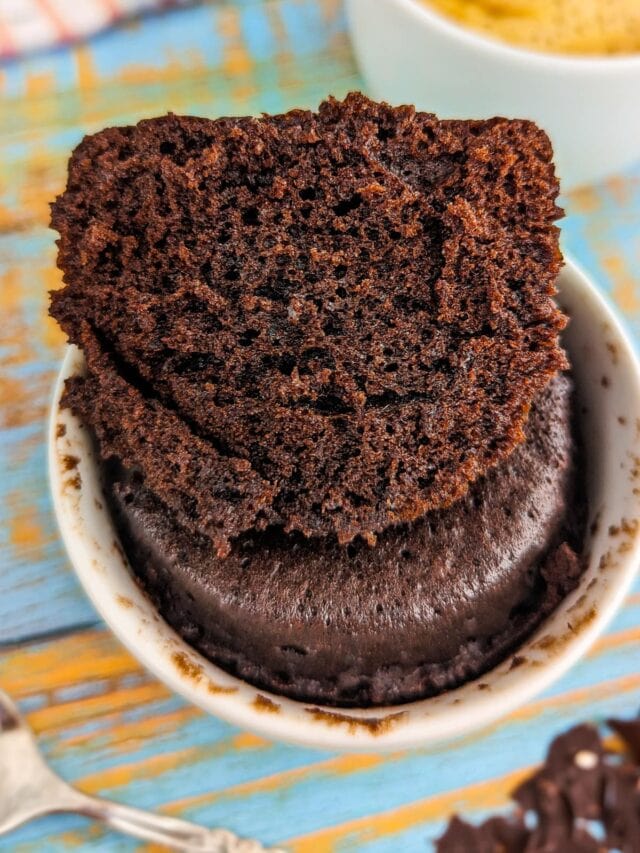 Close look of a mug with baked chocolate cake in the microwave.