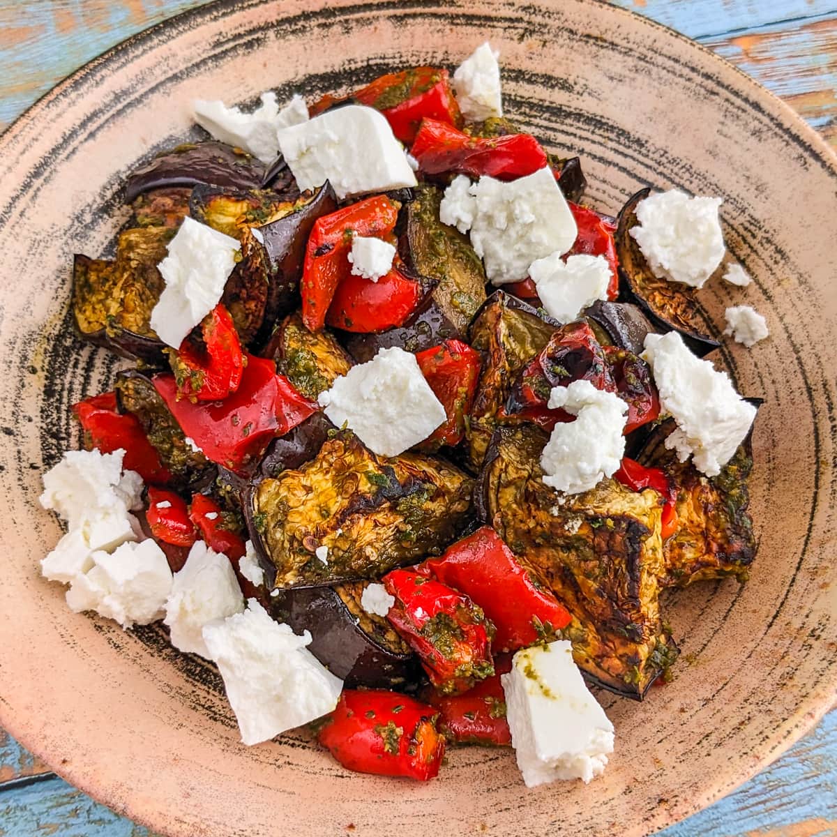 Rustic plate with eggplant, bell peppers and feta cheese salad.