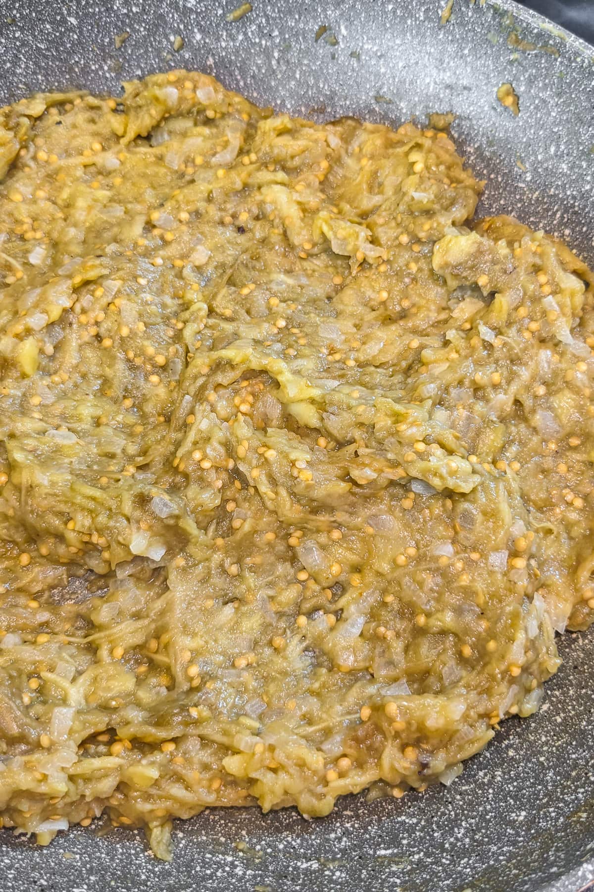 Close look of mixed eggplant dip in a frying pan.