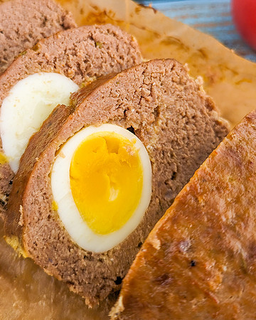 Close look of sliced meatloaf with boiled eggs inside.
